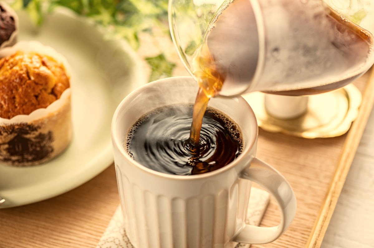淹れたてのコーヒーをカップに注ぐ手元
